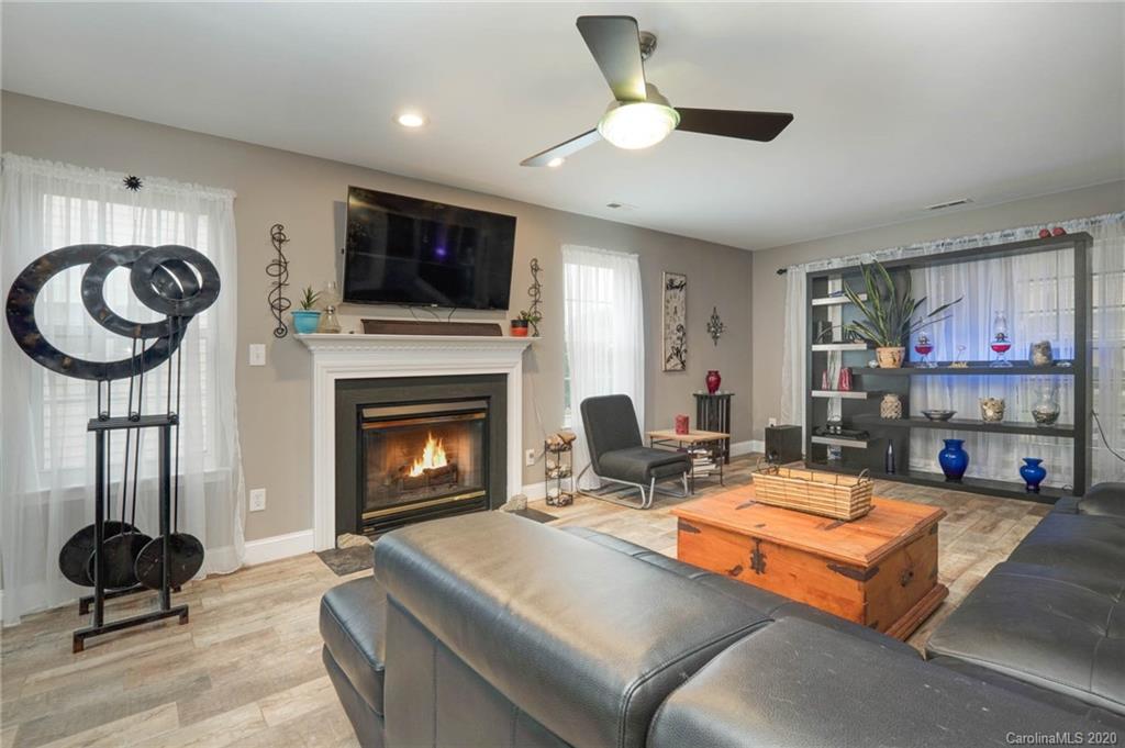 1433 Autumn Ridge Lane Fort Mill, SC 29708 - Photo 7 of 38 a living room with furniture a flat screen tv and a fireplace