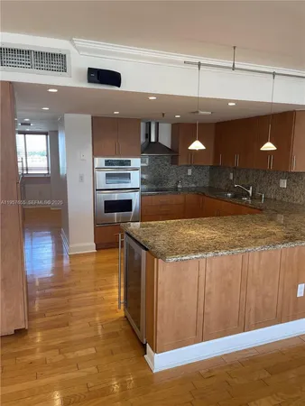 a kitchen with kitchen island a counter top a stove and a refrigerator