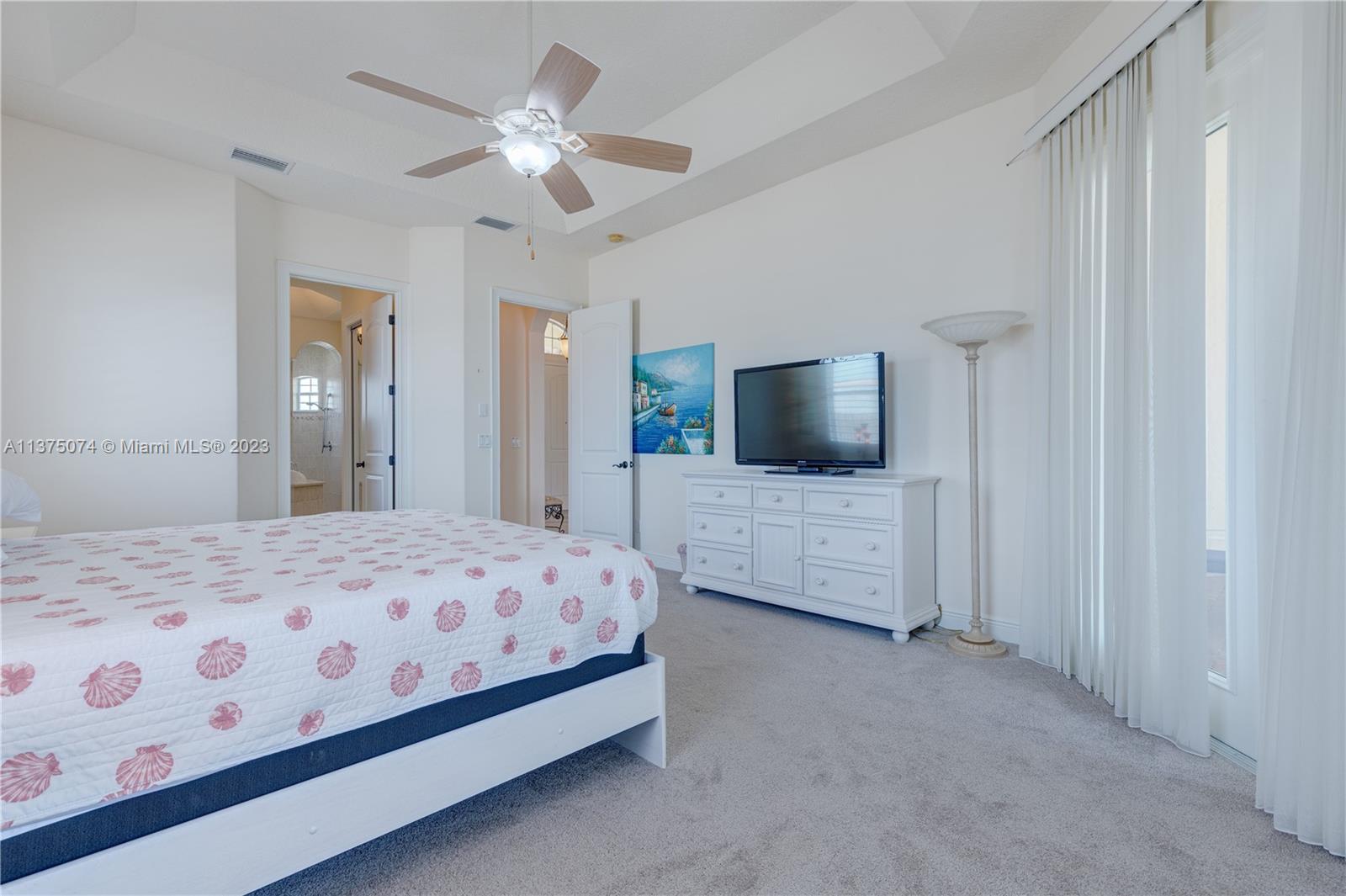 258 Bimini Road Cocoa Beach, FL 32931 - Photo 11 of 43 a bedroom with a large bed and a flat tv screen on dresser