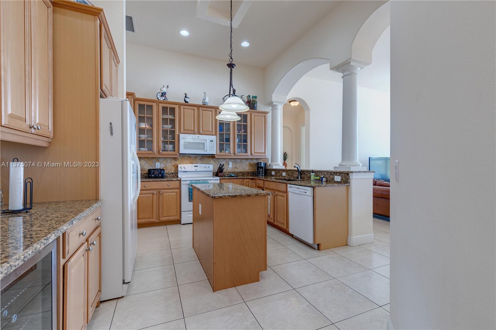 258 Bimini Road Cocoa Beach, FL 32931 - Photo 14 of 43 a kitchen with stainless steel appliances granite countertop a stove a sink and a refrigerator