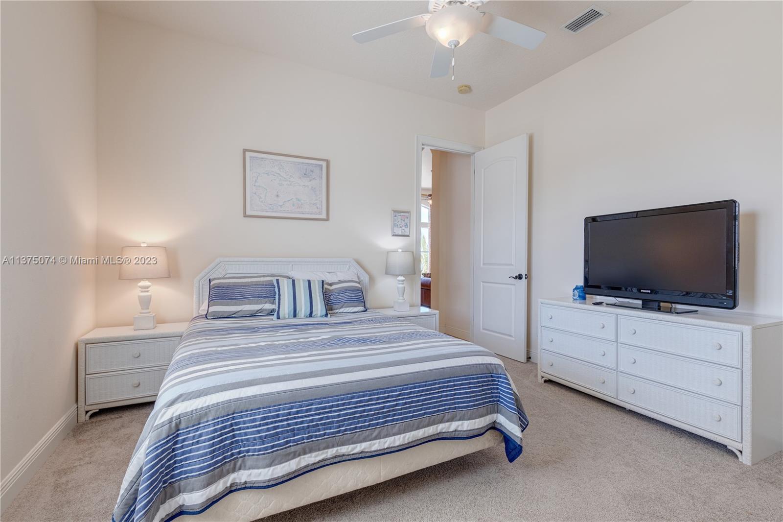 258 Bimini Road Cocoa Beach, FL 32931 - Photo 26 of 43 a bedroom with a bed and a flat screen tv