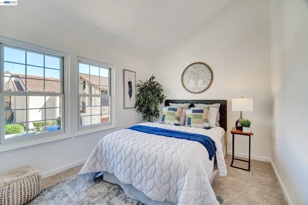 a bed sitting in a bedroom next to a window