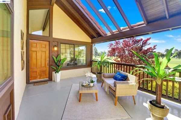 a porch with chairs and table in patio