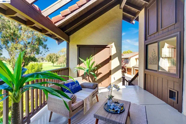 a balcony with furniture and a potted plant