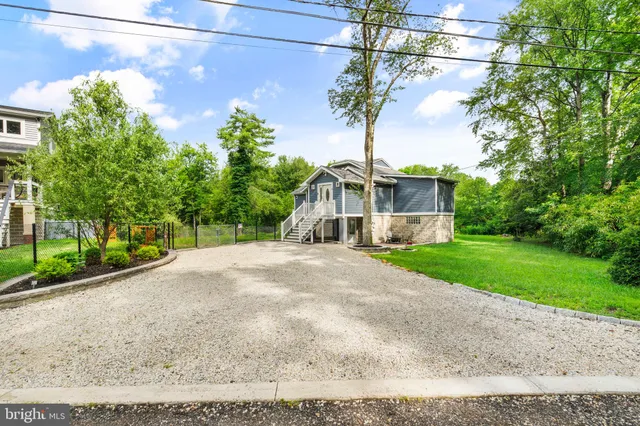 a front view of a house with a yard and trees