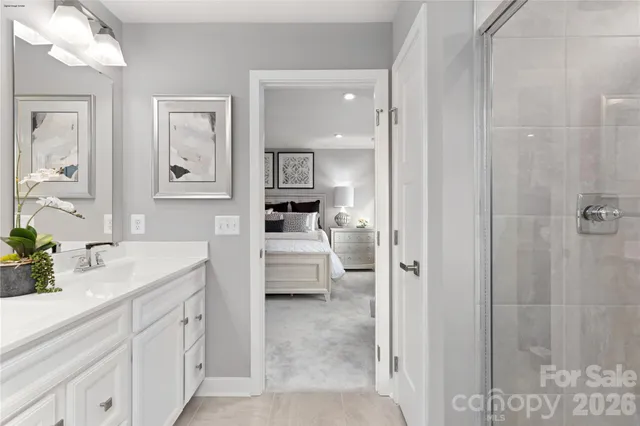 a en suite bathroom with a granite countertop sink mirror and a shower