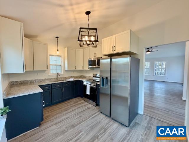 93 West Cedar Drive Ruckersville, VA 22968 - Photo 5 of 29 a kitchen with stainless steel appliances granite countertop a refrigerator a sink dishwasher a stove and white countertops with wooden floor