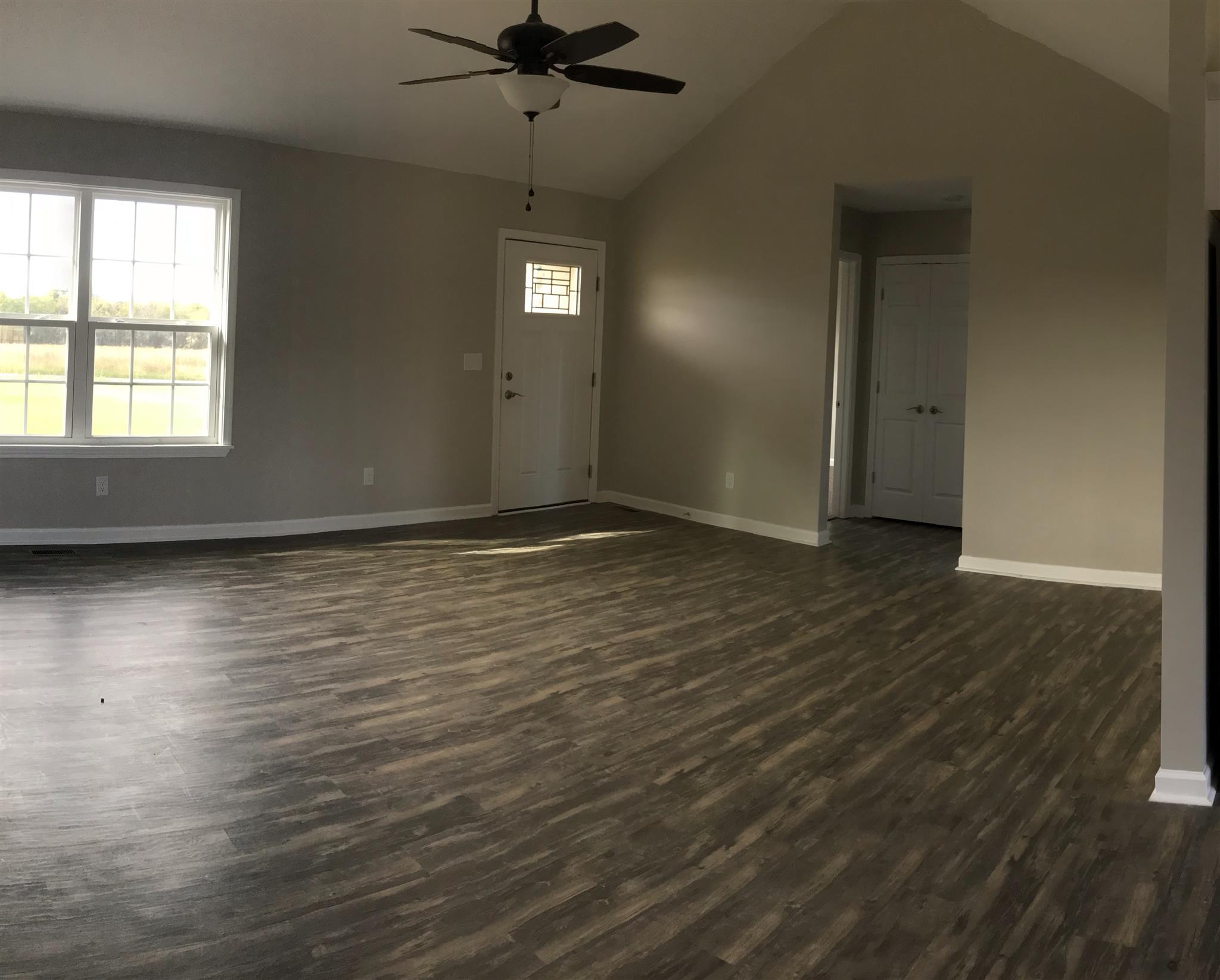 143 B T G T Road Portland, TN 37148 - Photo 4 of 15 an empty room with wooden floor cabinet and windows