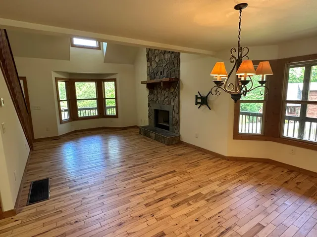 a hallway with wooden floor windows and a chandelier