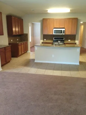 a kitchen with a sink a stove a microwave and cabinets