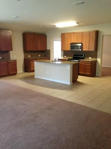 a large kitchen with cabinets a sink and a stove
