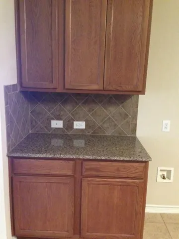 a kitchen with granite countertop cabinets and white stainless steel appliances