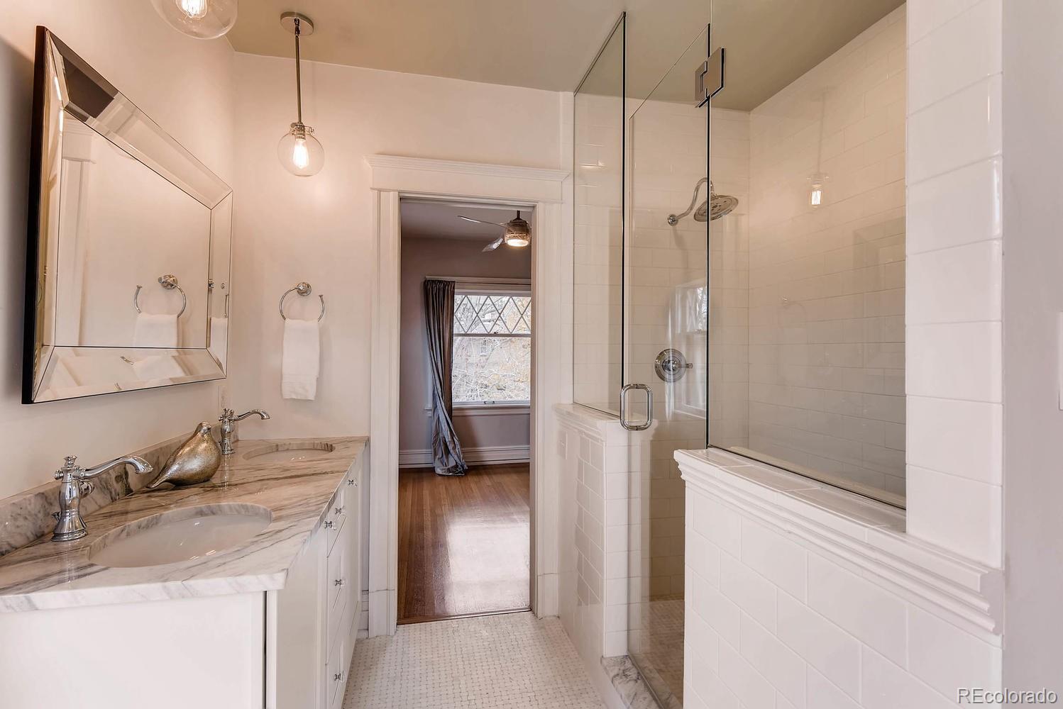 2030 Park Place Denver, CO 80205 - Photo 17 of 28 a bathroom with a granite countertop sink a mirror and shower