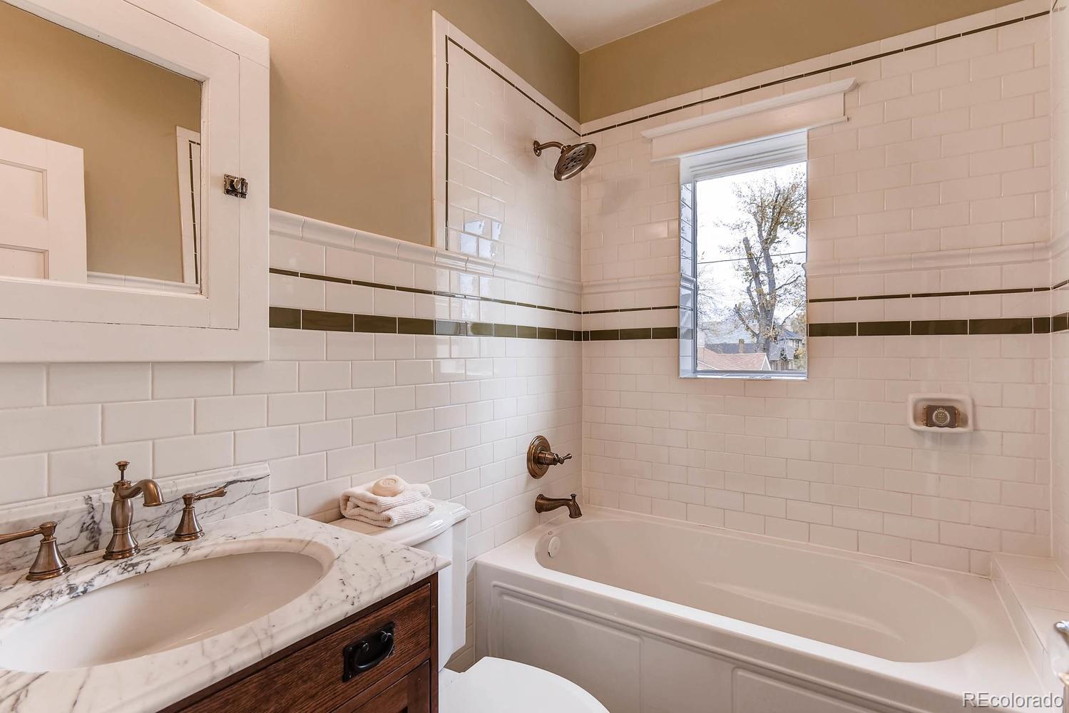2030 Park Place Denver, CO 80205 - Photo 20 of 28 a bathroom with a granite countertop sink mirror toilet and bathtub