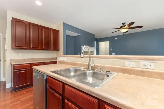a kitchen with stainless steel appliances granite countertop a sink a stove and dishwasher