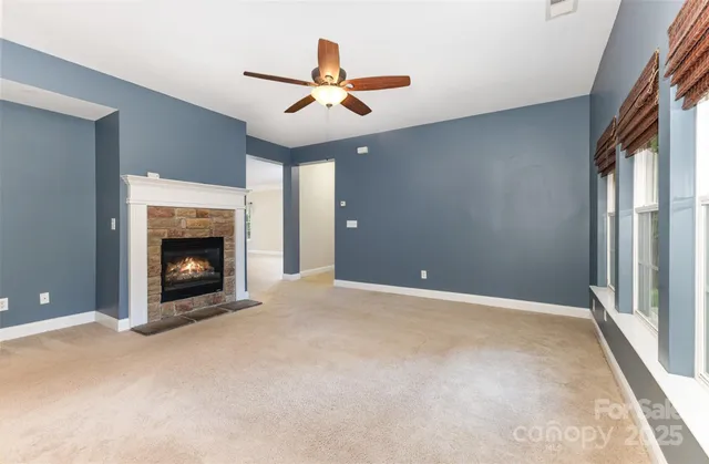 a view of an empty room with a fireplace and a window