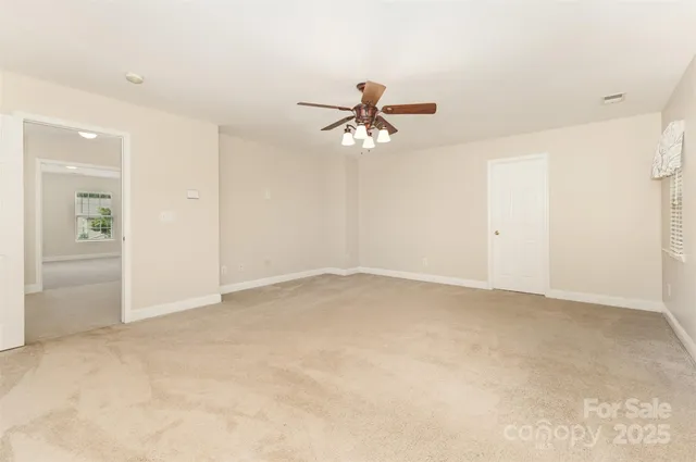 an empty room with closet and a ceiling fan