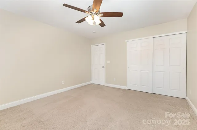 an empty room with a ceiling fan and a window