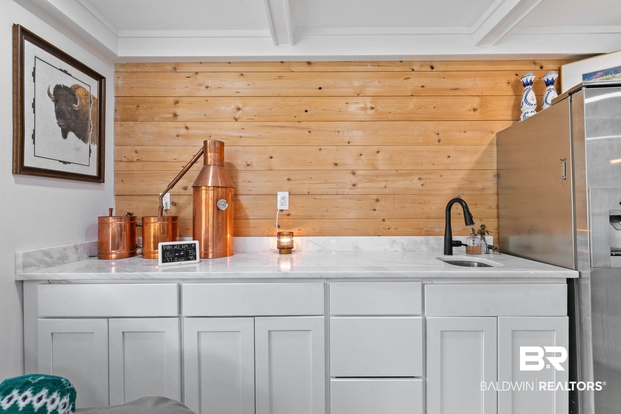 520 Juniper Place Drive Foley, AL 36535 - Photo 25 of 35 White cabinetry with contemporary hardware, light-toned countertop, integrated sink with matte black faucet, and a wood-paneled accent wall