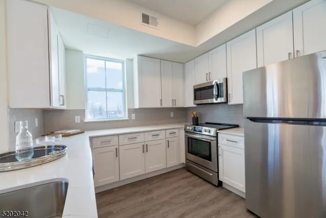 a kitchen with white cabinets and stainless steel appliances
