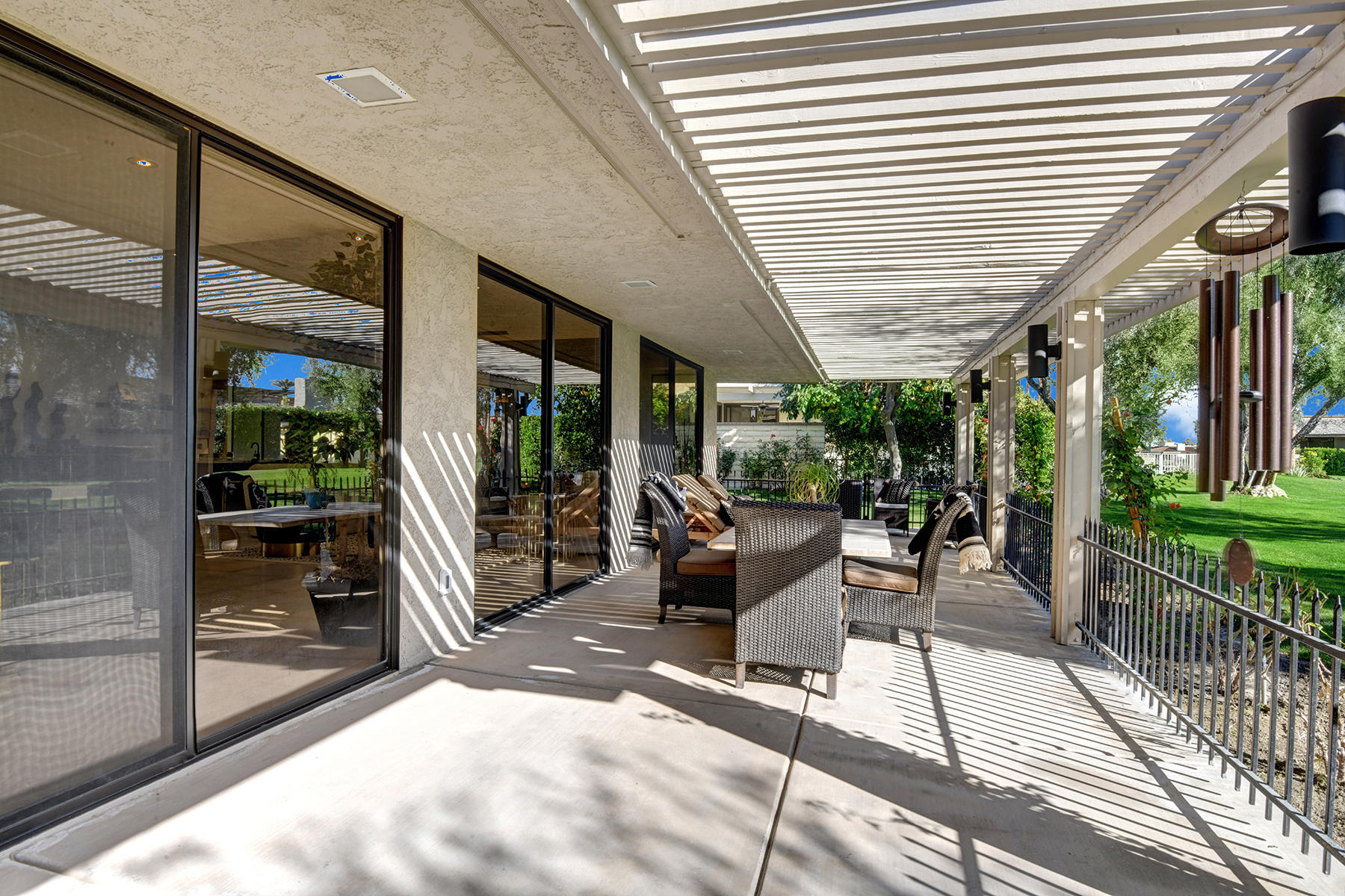 13 Rutgers Court Rancho Mirage, CA 92270 - Photo 35 of 42 a view of a patio with table and chairs potted plants with wooden floor and fence