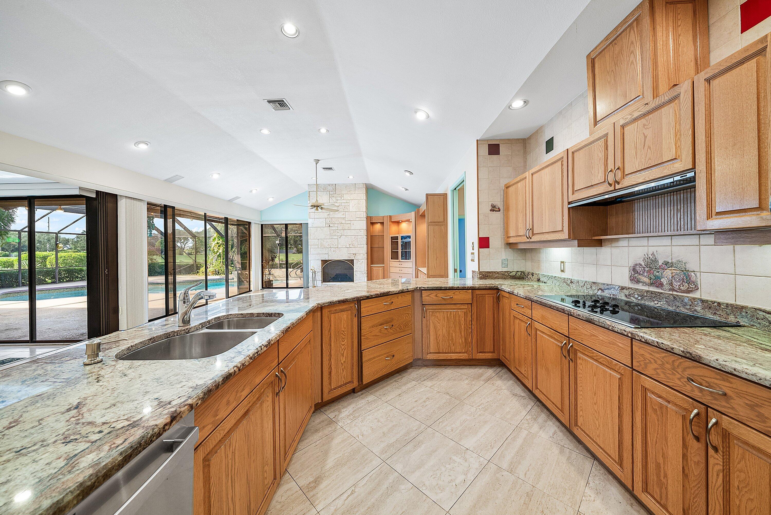 4952 Bocaire Boulevard Boca Raton, FL 33487 - Photo 15 of 61 a large kitchen with granite countertop a sink and white cabinets