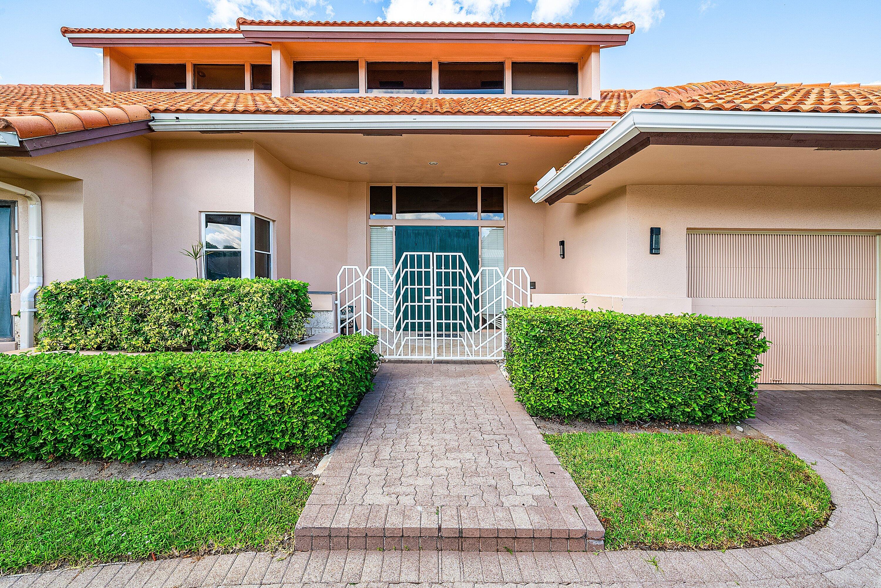 4952 Bocaire Boulevard Boca Raton, FL 33487 - Photo 2 of 61 a front view of a house with a yard