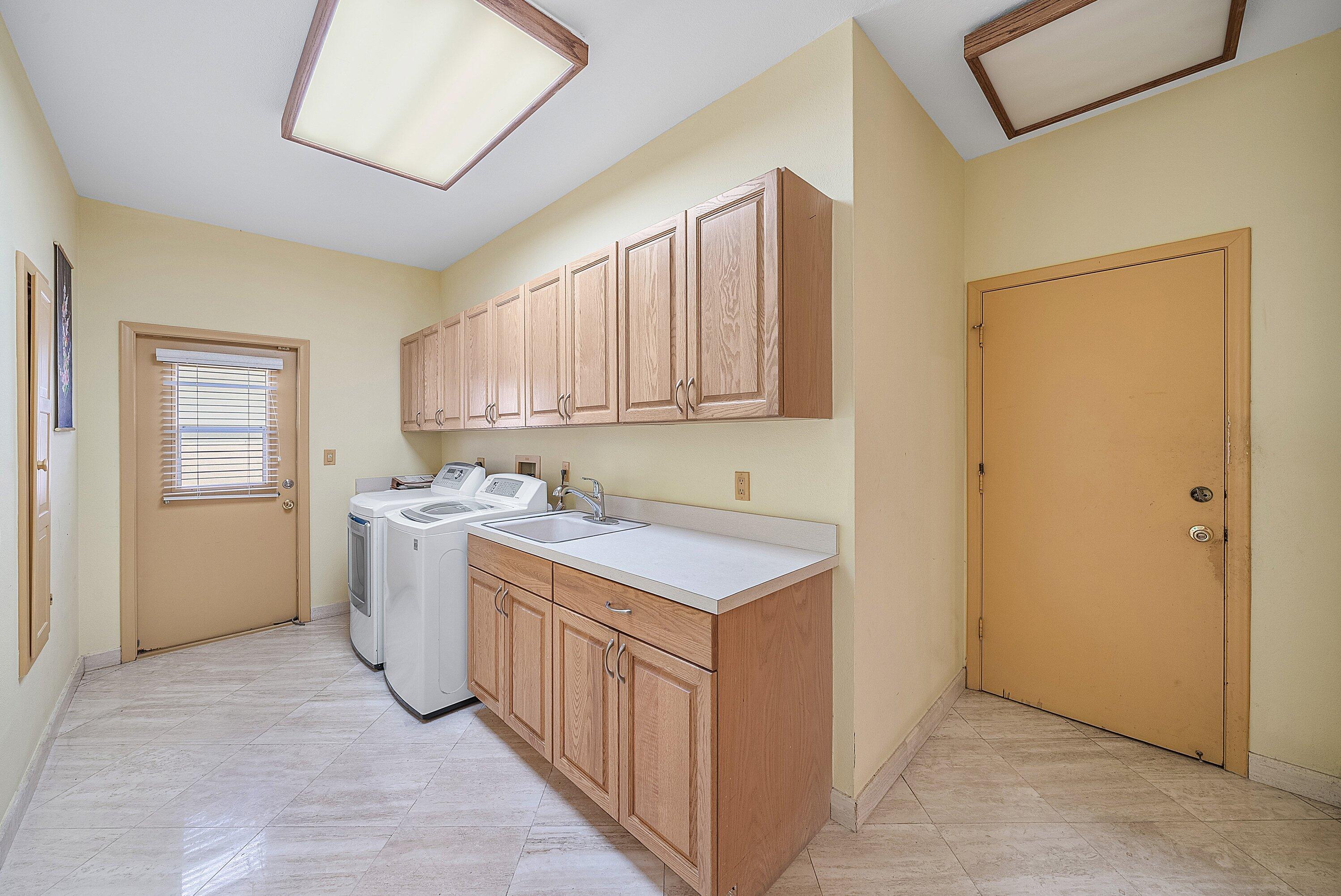 4952 Bocaire Boulevard Boca Raton, FL 33487 - Photo 31 of 61 a utility room with a sink a washer and dryer