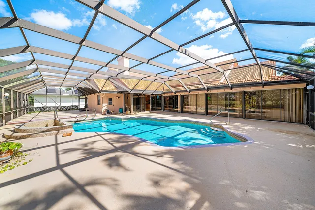 an aerial view of a house with swimming pool and garden