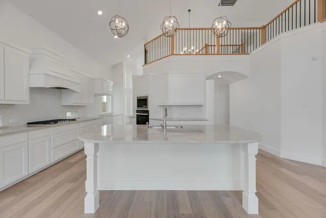 a kitchen with stainless steel appliances a white cabinets and wooden floor