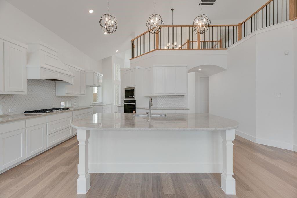 3517 Laurel Court Corinth, TX 76208 - Photo 11 of 30 a kitchen with stainless steel appliances a white cabinets and wooden floor