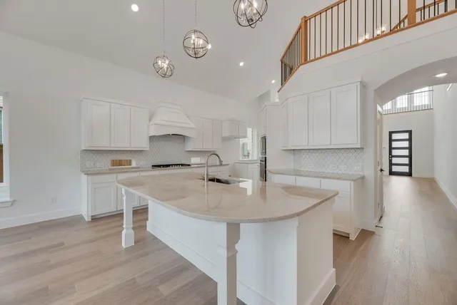 a kitchen with a sink cabinets and wooden floor
