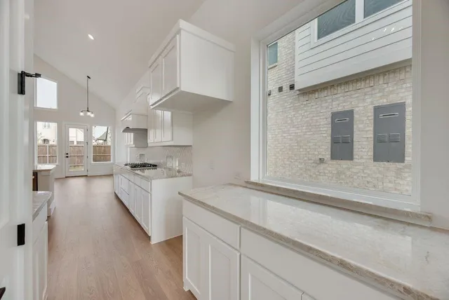 a large white kitchen with kitchen island white cabinets and stainless steel appliances