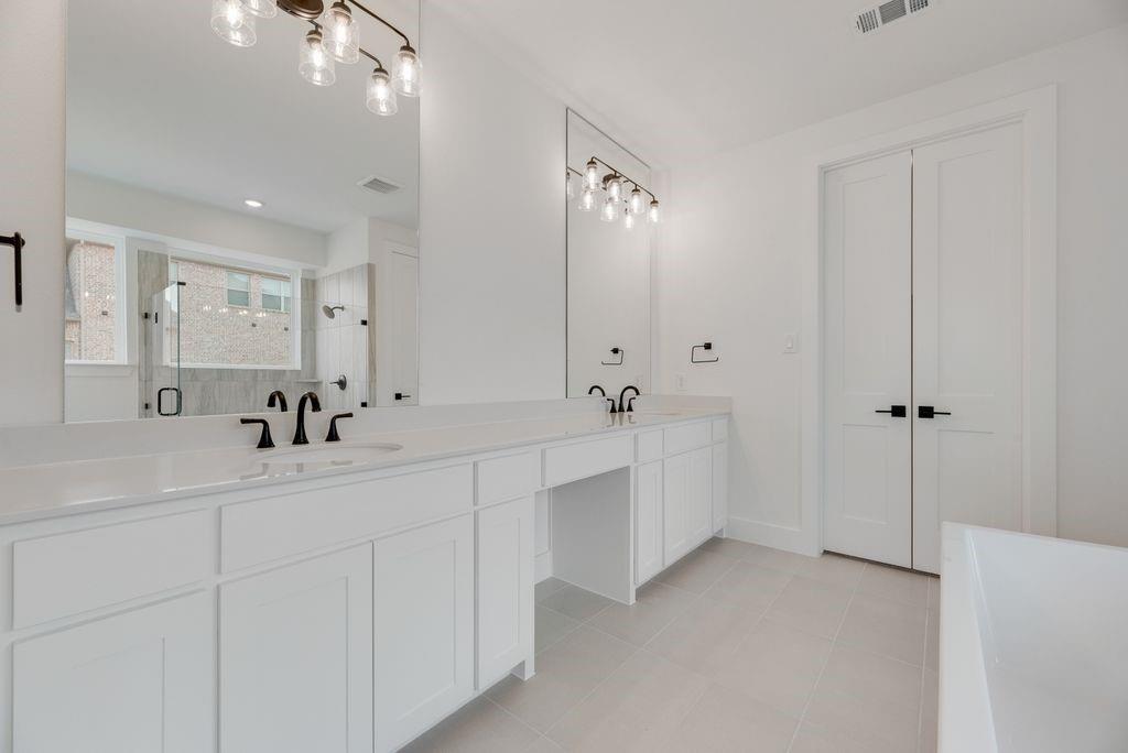 3517 Laurel Court Corinth, TX 76208 - Photo 19 of 30 a bathroom with a double vanity sink mirror and