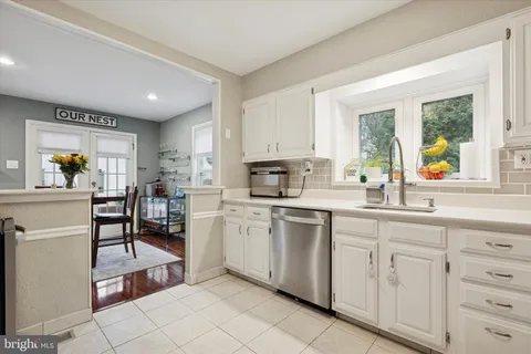 a kitchen with white cabinets and appliances