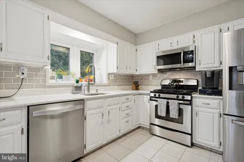 a kitchen with white cabinets and white appliances