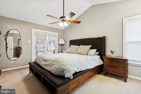 a bed sitting in a bedroom next to a window and a chandelier