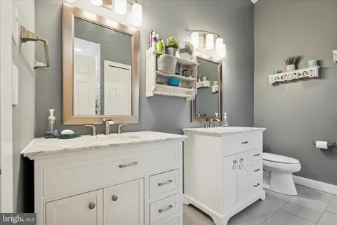 a bathroom with a granite countertop sink vanity mirror and a