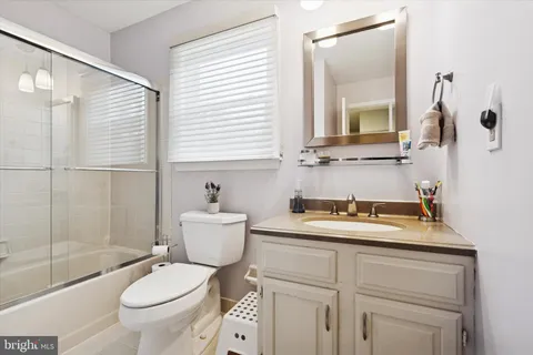 a bathroom with a granite countertop toilet sink and mirror