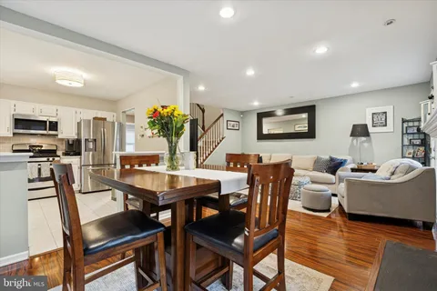 a view of a dining room with furniture a rug and wooden floor