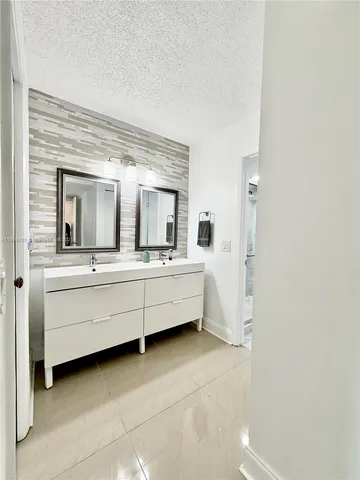 a bathroom with 2 sink and a mirror