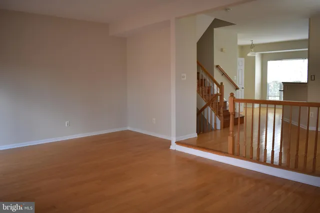 a view of a hallway with wooden floor and entryway
