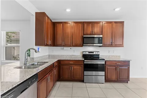 a kitchen with stainless steel appliances granite countertop wooden cabinets a stove top oven a sink and dishwasher