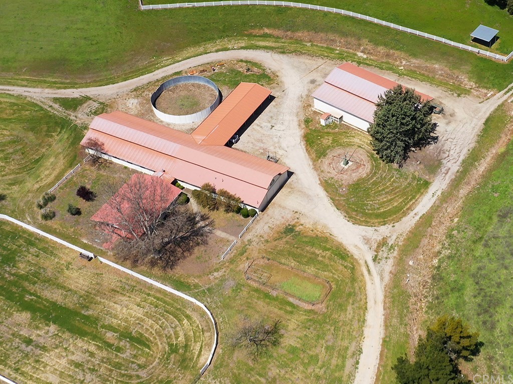 8800 Vineyard Drive Paso Robles, CA 93446 - Photo 45 of 74 An aerial view of the 22 stall barn, arena, round pen and exercising areas. There is a very large office, meeting room attached to the garage which has a kitchen and bath and could be easily converted to a guest house, tasting room or other use. The barn has grooming areas, office, kitchen and bath rooms as well. The entire horse facility is surrounded by fenced pasture and is accessed by well placed ranch roads. There are other buildings and covered areas for parking equipment or additional vehicles.