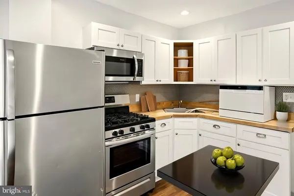 a kitchen with stainless steel appliances white cabinets and a stove