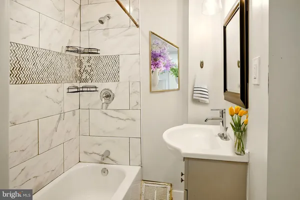 a bathroom with a sink and bathtub with shower