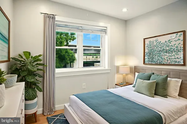 a bedroom with a bed table and a window