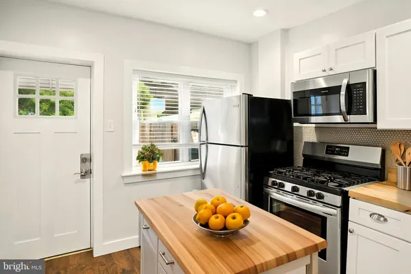 a kitchen with stainless steel appliances a stove a refrigerator and a refrigerator