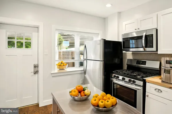 a kitchen with stainless steel appliances a stove a refrigerator and a window