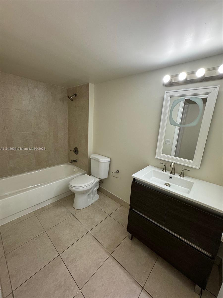 4025 West McNab Road, Unit E109 Pompano Beach, FL 33069 - Photo 13 of 13 a bathroom with a double vanity sink toilet and a tub